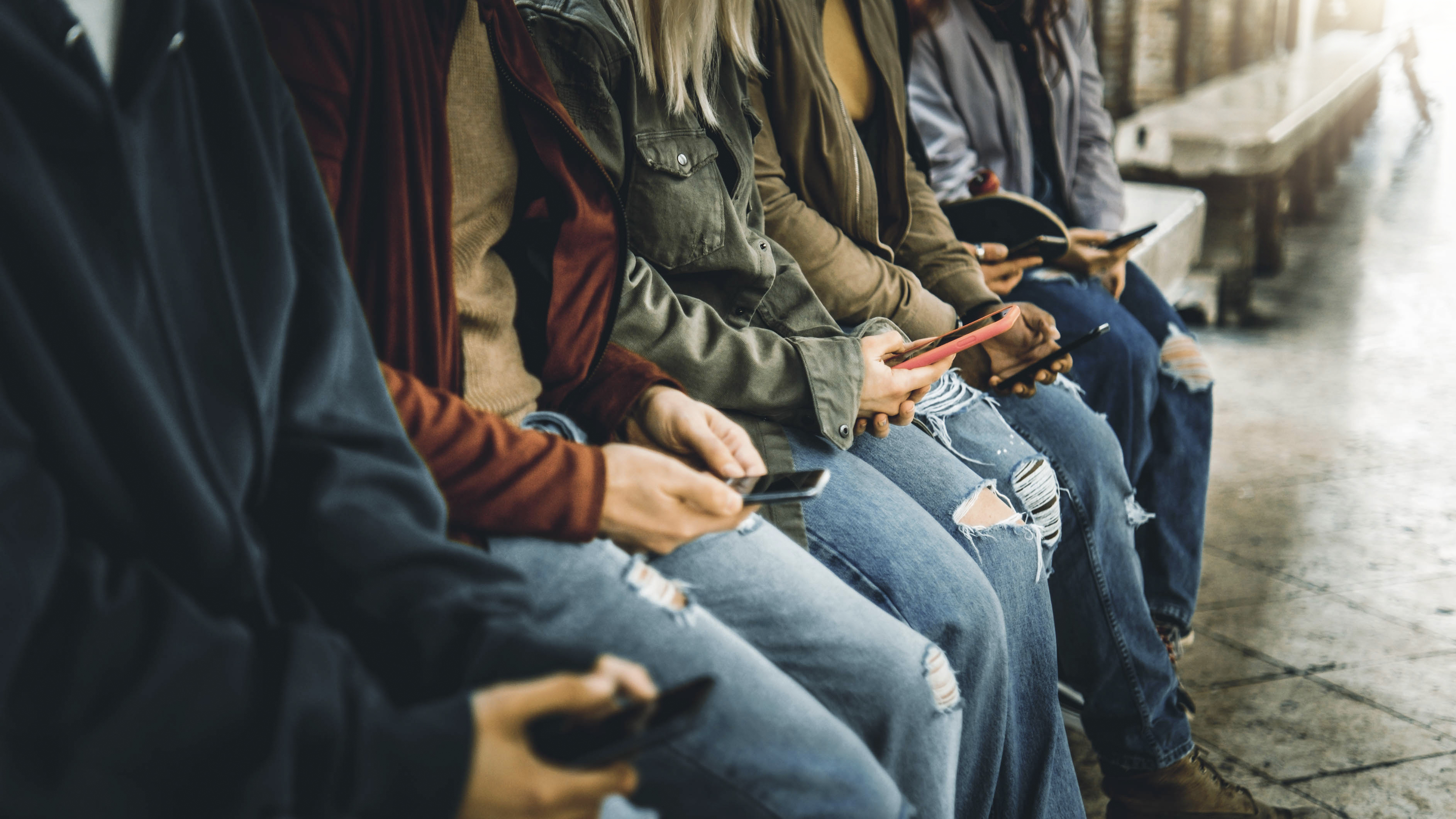 Millenial people watching smart mobile phones outside - Teens us